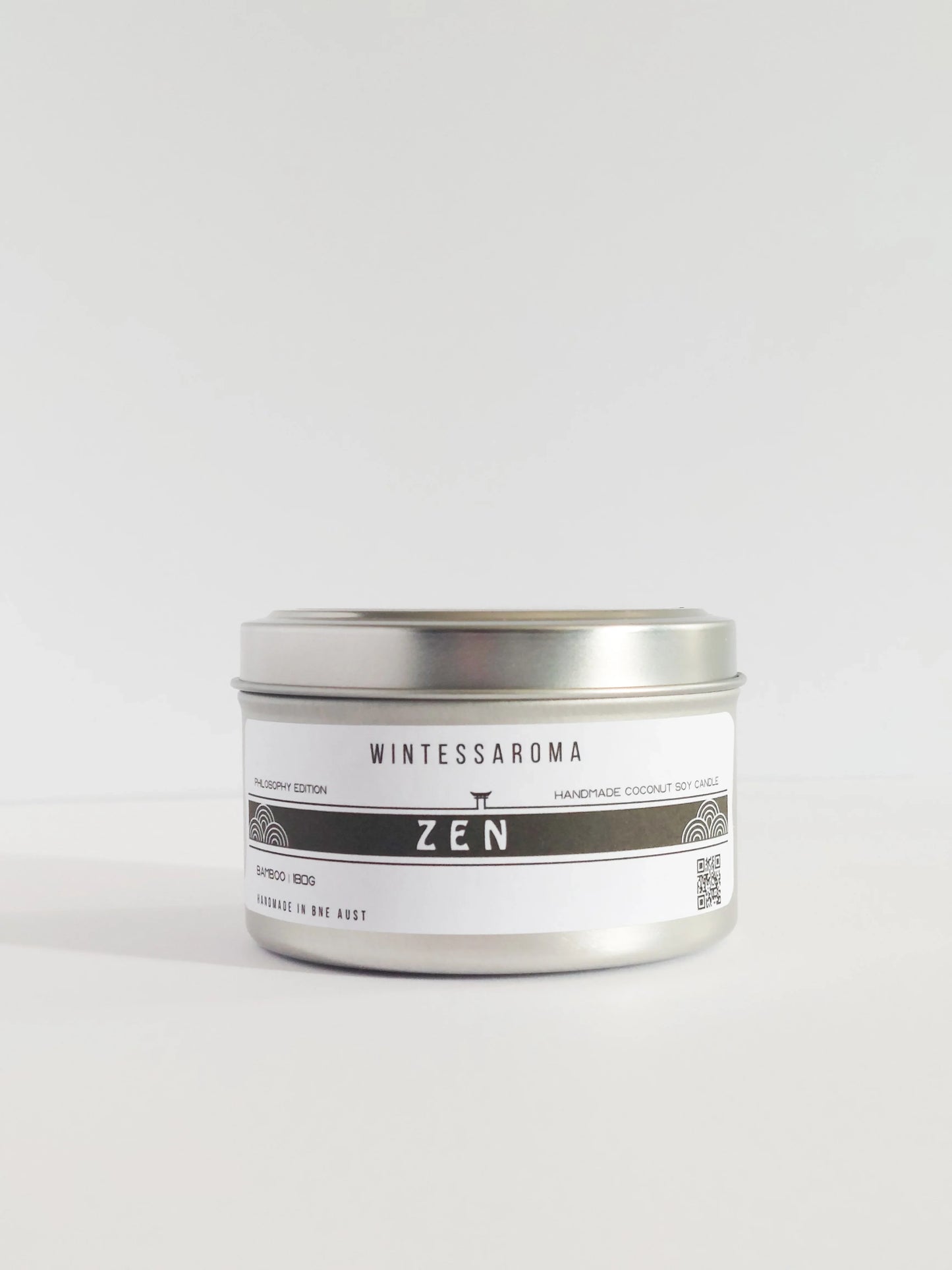 Candle in a silver tin labeled 'Wintessaroma Zen' on a white background