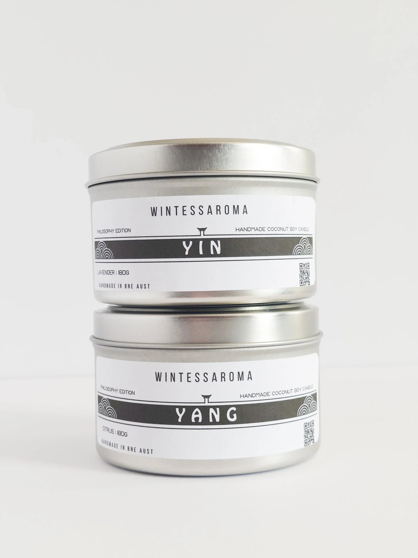 A set of two candles with labels indicating 'WINTESSAROMA' and different scents, placed on a white background.