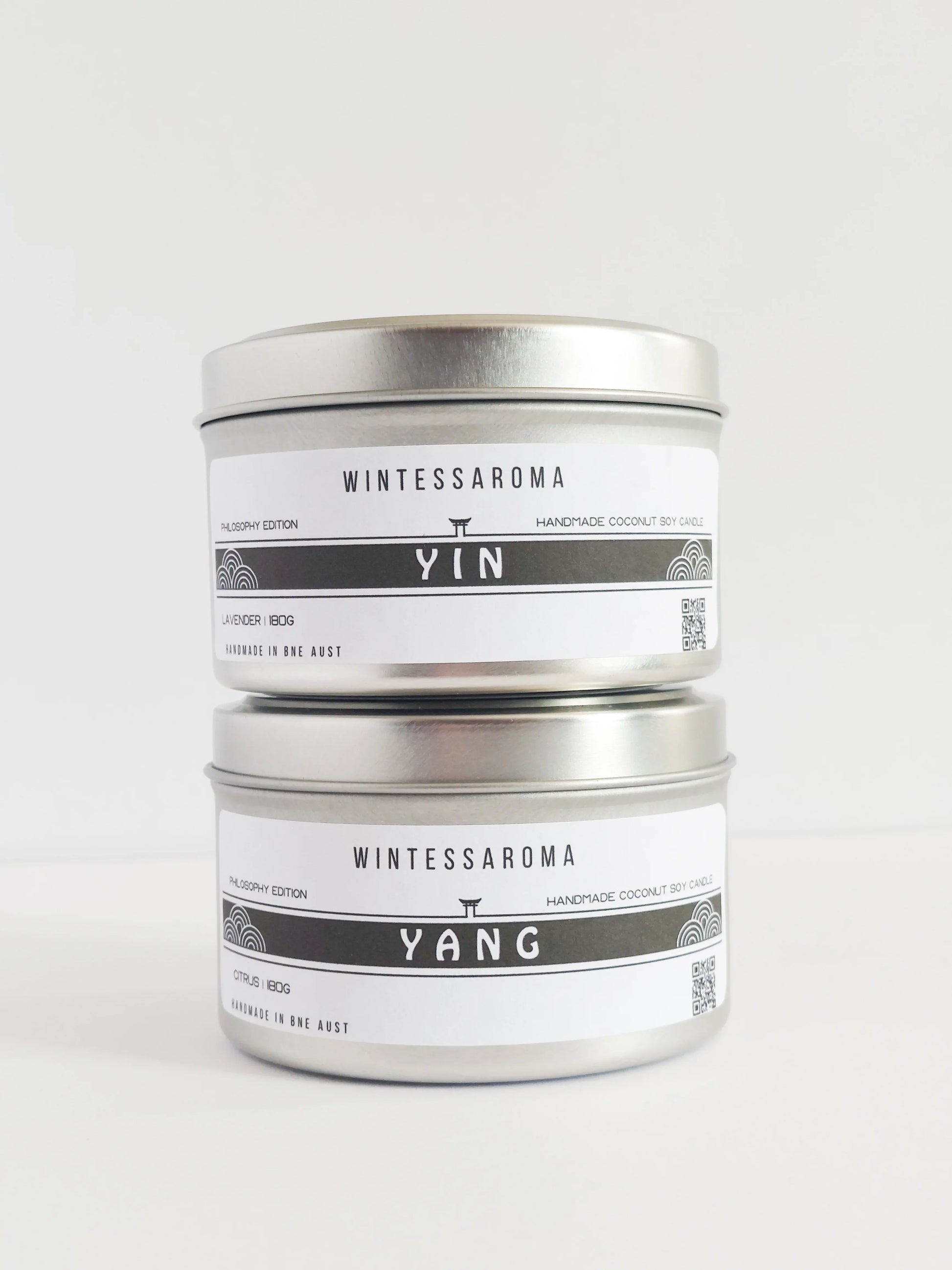 A set of two candles with labels indicating 'WINTESSAROMA' and different scents, placed on a white background.
